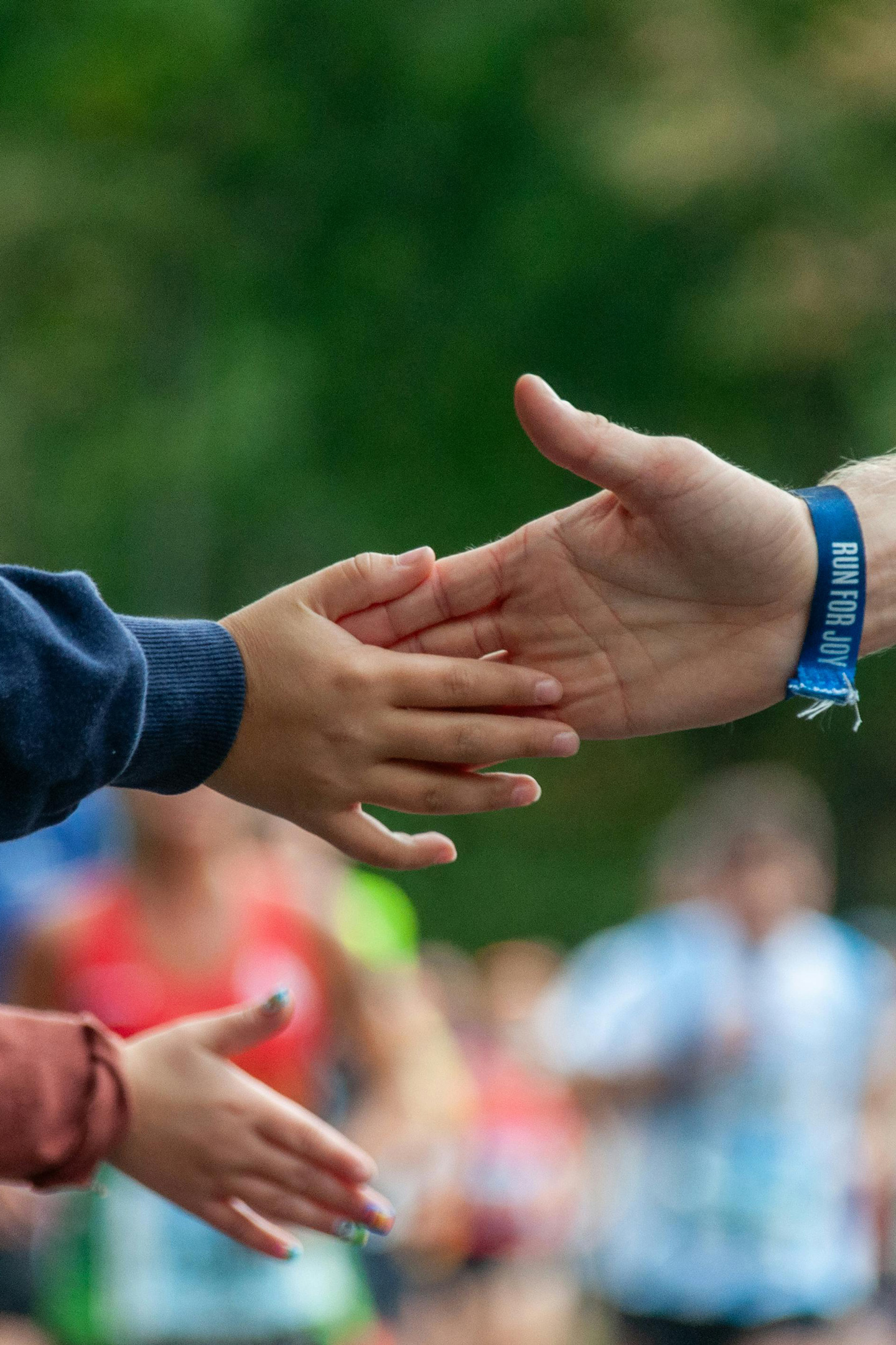 A runner's hand giving a high five to a supporter.